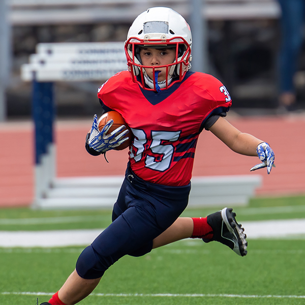 Athletic Football player catching and running with the ball during a game